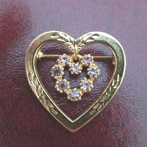 Gold-tone heart brooch with second dangling rhinestone interior heart